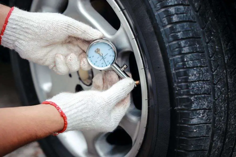checking tire pressure with meter